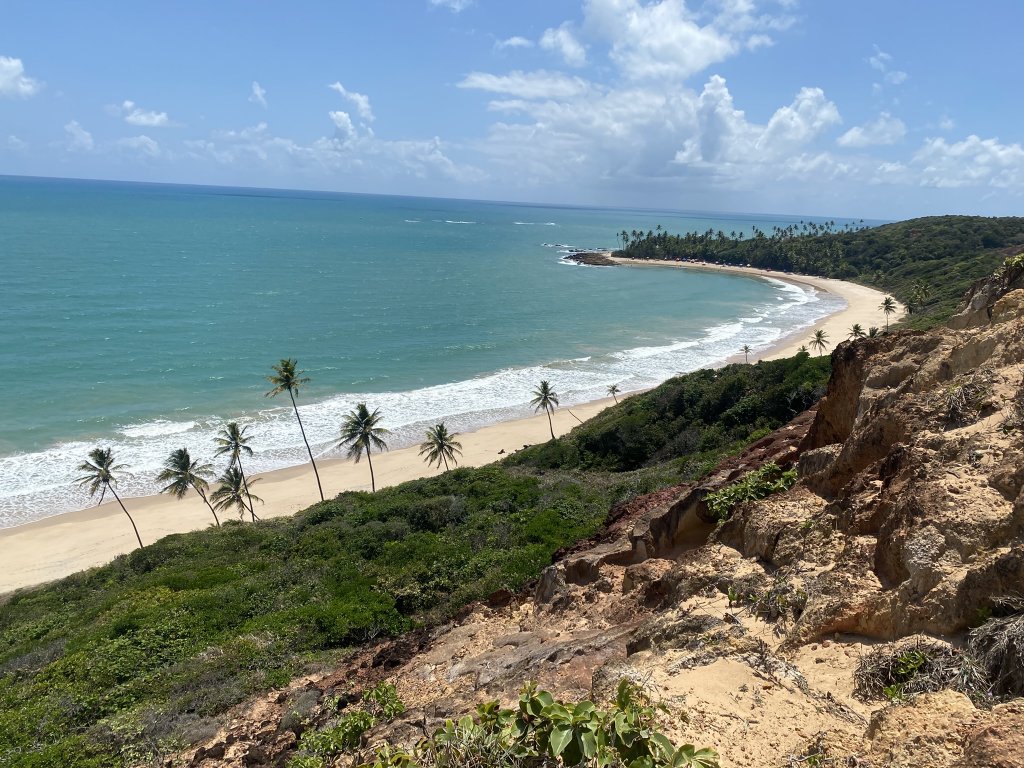 Blick von den Klippen auf den Praia de Coqueirinho mit Palmen, Sand und türkisblauem Meer – einer der schönsten Strände im Süden von João Pessoa