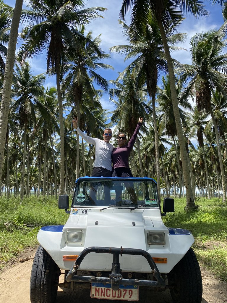 Weißer Buggy mit zwei Personen zwischen endlosen Reihen von Palmen während einer Tour bei Lucena, nördlich von João Pessoa