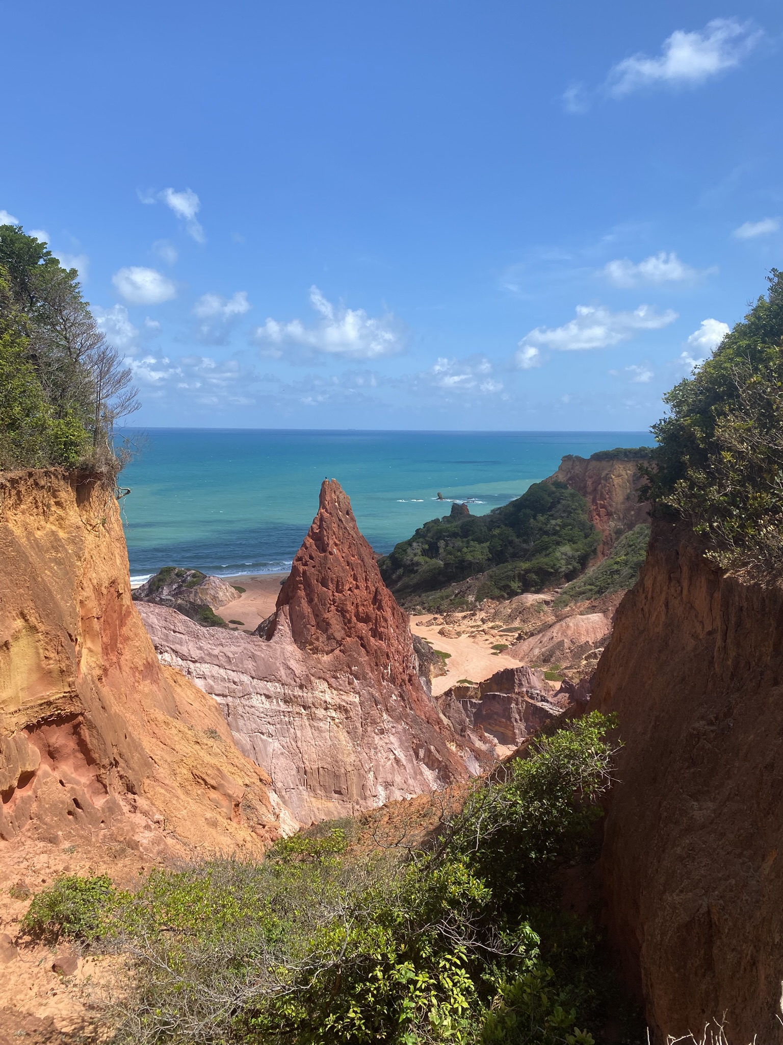 Praia da Arapuca in João Pessoa mit pyramidenförmigem Felsen in roter Erde, Klippen und türkisfarbenem Meer