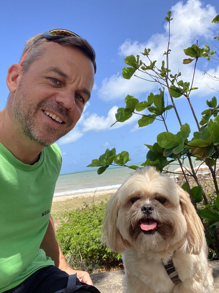 Autor mit Hund an der Strandpromenade in João Pessoa, Palmen und Meer im Hintergrund