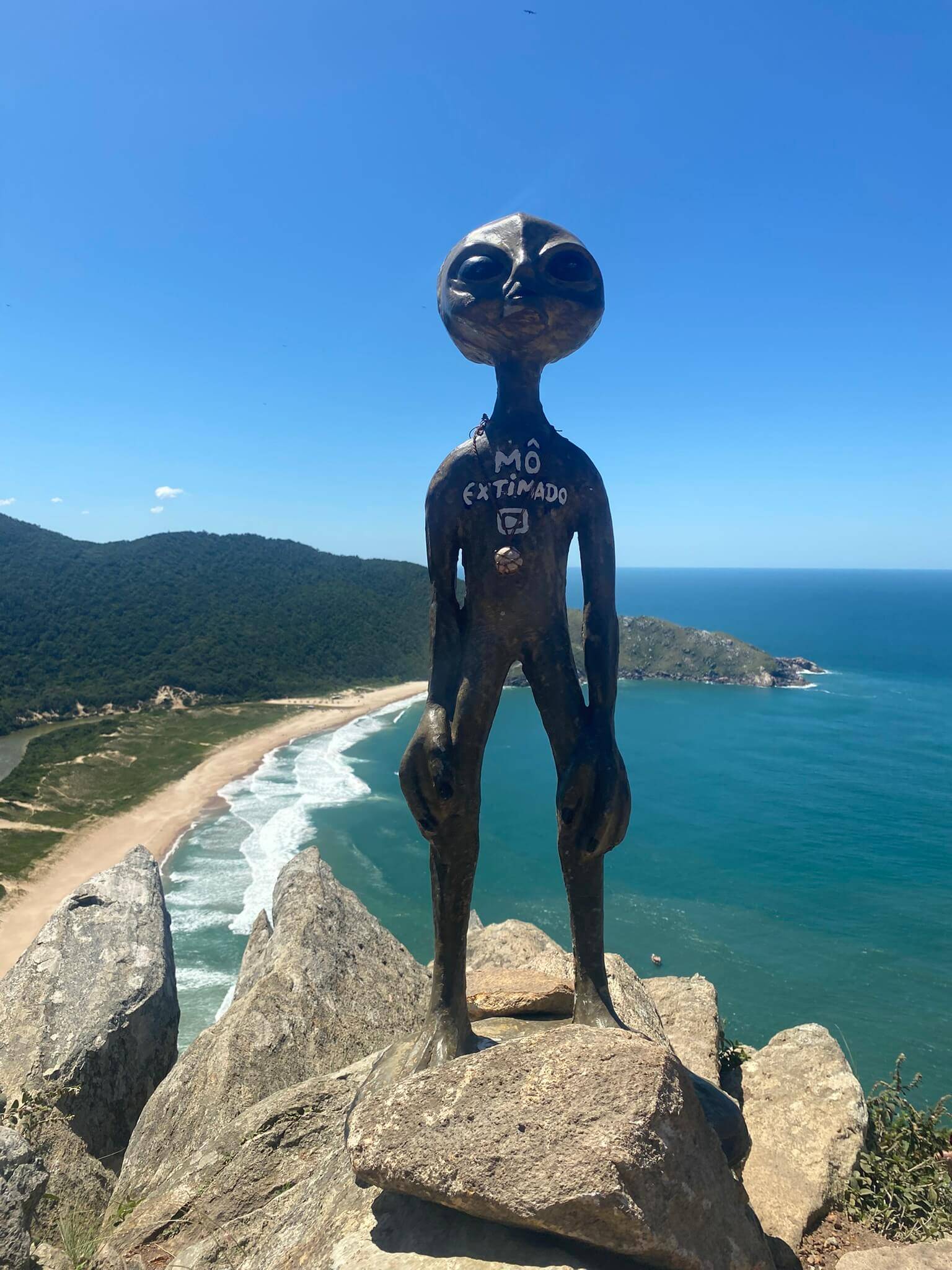 Aussicht vom Morro da Coroa auf die Praia da Lagoinha do Leste in Florianópolis mit einer Alienfigur am Hügel